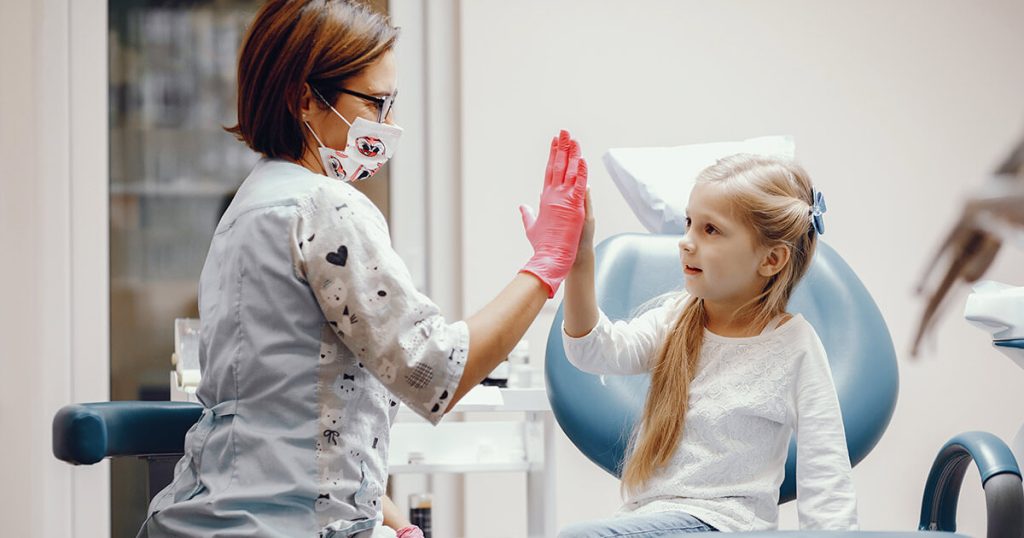 Explicación sobre los dientes separados a una niña paciente