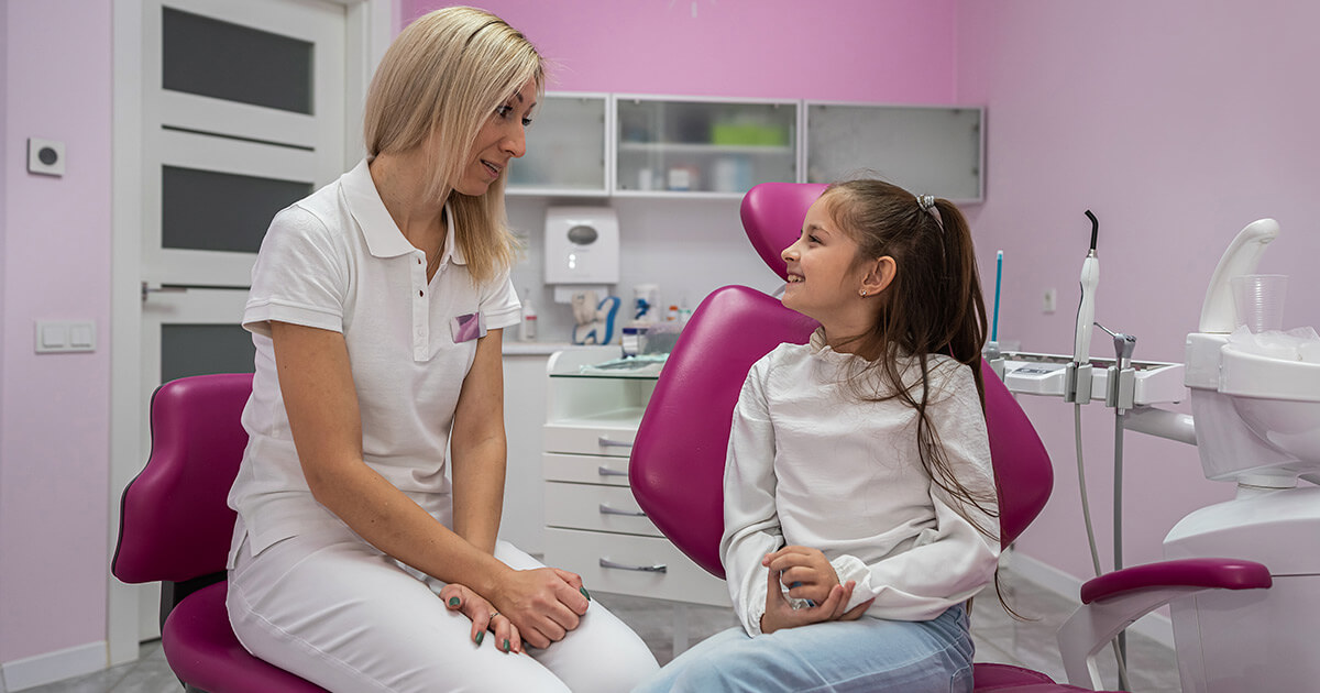 Odontopediatra tratando a niña con problemas de ortodoncia y mordida